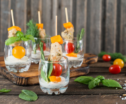Grilled chicken with sause and vegetable  salad in cocktail glasses for party. Creative food presentation.  Food snacks and appetizers.