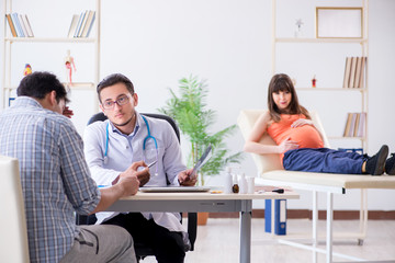 Pregnant woman with her husband visiting the doctor in clinic