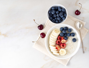 Large bowl of tasty and healthy oatmeal with fruits and berry for Breakfast, morning meal. Top view, copy space