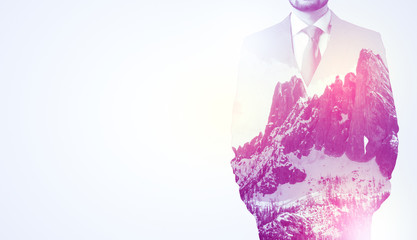  Young businessman in suit standing with sunny snowy mountain and trees graphic.