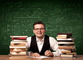 A young passionate male teacher sitting at school desk, reading a book, with area algorythm...