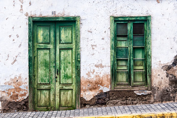 Fototapeta na wymiar Green door and window of an old house in Spain
