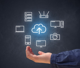 Cloud and computing related icons hovering over young hand 
