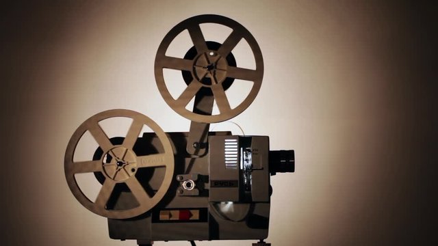 Movie projector 8-mm film. The film projector is loaded with a film and a film is shown.