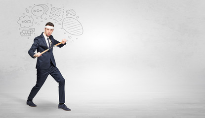 Young businessman in suit fighting with doodled symbols concept
