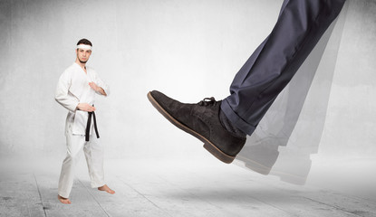 Big foot trample young karate trainer concept
