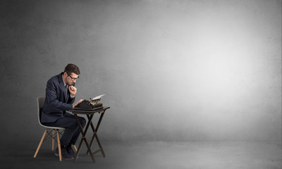 Man working hard on a typewriter in an empty space
