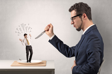 Huge businessman starting to eat small businessman
