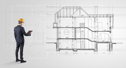 Architect watching a 2 dimension house plan
