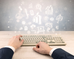 First person view of an elegant businessman hand typing with doodle report and chart concept