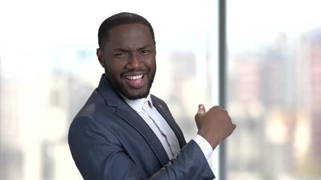Happy surprised macho-man on blurred background. Satisfied dark-skinned businessman. Playful macho-man.