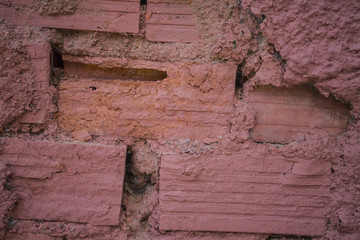 Dark orange colored brick wall. Clayish material walled construction and building. Hardened by the heat of the sun. Used for building homes, establishments and other architectural structure.