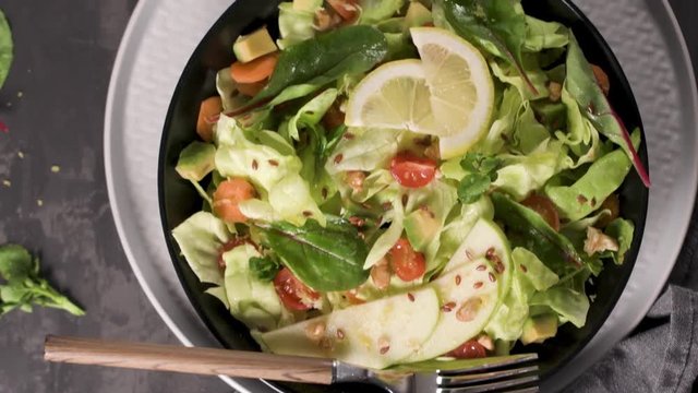 Delicious vegetable salad with apple slices  in ceramic bowl on table.