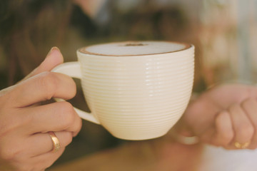 Hands of young women and mocha coffee.