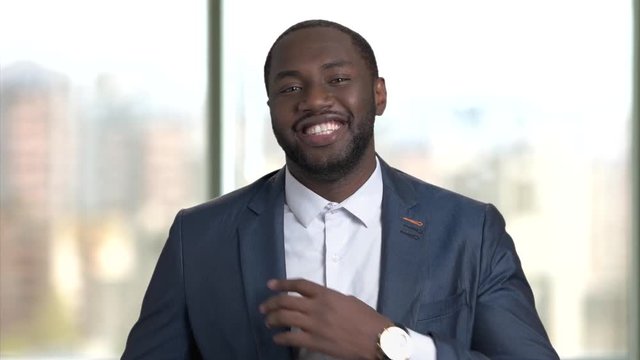 Sexy businessman adjusting his suit. Satisfied macho-man on blurred background.