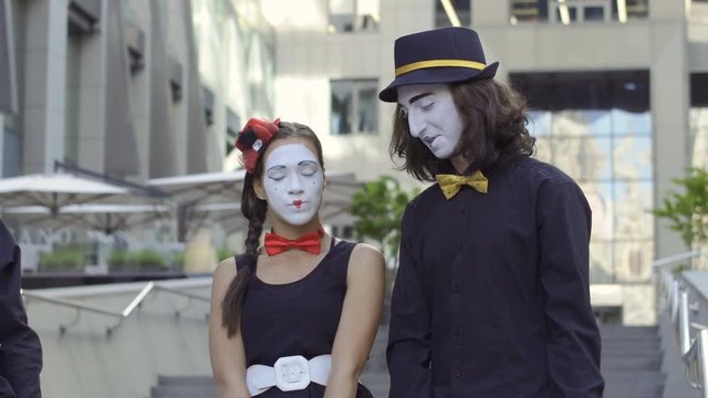 Funny mimes show love comic scene at blurred office center background