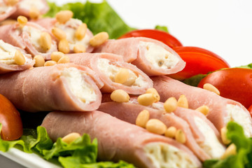 meat rolls with ham, cheese and greens, on white background