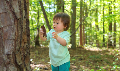 Young toddler boy playing in the forest