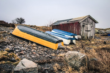 Old fishing boats next to cabin in ruin