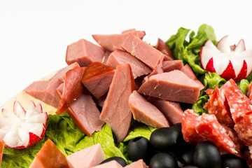 plate Board with meat and cheese. The Banquet in the Italian style.