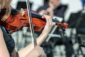musician playing violin instrument on street concert. closeup view