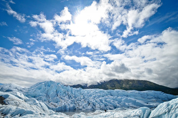 glacier with mountains and beautiful white clouds