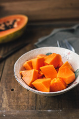 Papaya sliced bowl for preparing salad fruits exotic. Food wooden rustic background. Top view.