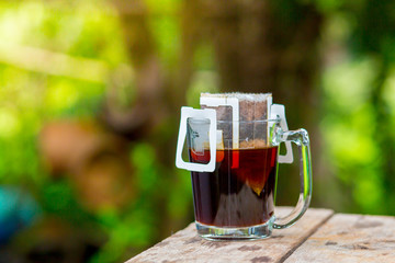 Hot coffee drip in the morning, sunlight shining in green.