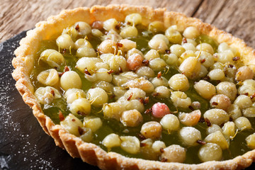 Delicious summer dessert: gooseberry tart on a close-up on a table. Horizontal
