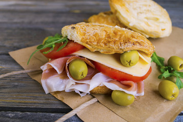 a sandwich with ham and cheese on an old wooden background