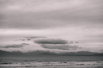 Beautiful scene of the beach with snow mountain at dusk. Black and white effect.