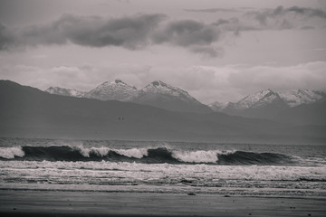 Beautiful scene of the beach with snow mountain at dusk. Black and white effect.