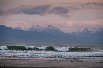 Beautiful scene of the beach with snow mountain at dusk.