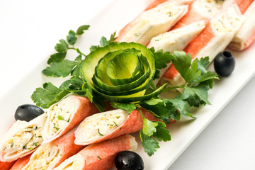 Crab sticks with lettuce and dill on brown wooden cutting board