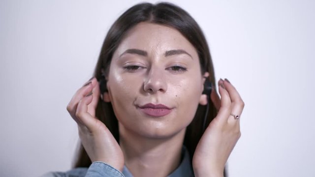 Ragazza con auricolari ascolta la musica e parla al telefono