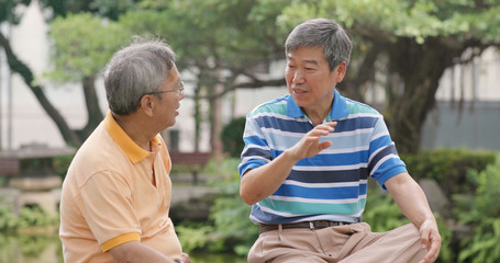 Senior friends chatting together at outdoor park