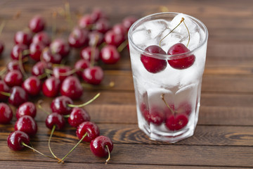 Summer iced drink -  cherry with ice. On rustic wooden table