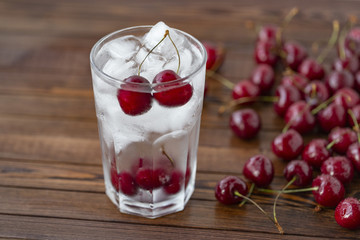 Summer iced drink -  cherry with ice. On rustic wooden table