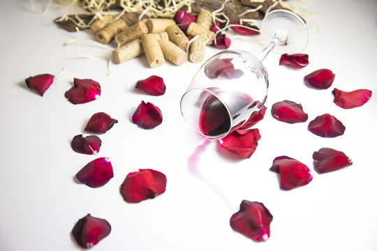 Glass of wine on the table with rose petals