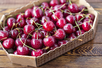 Red ripe cherries, red cherries on wooden table, brown wooden background, top view
