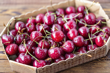 Red ripe cherries, red cherries on wooden table, brown wooden background, top view