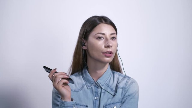 Ragazza con auricolari ascolta la musica e parla al telefono