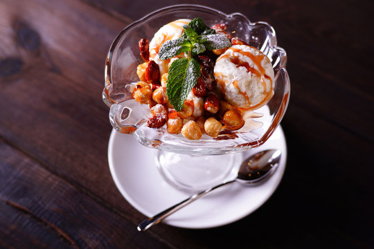 Vanilla ice cream with caramel sauce and caramelized nuts, refreshing summer sweets, seasonal meals, restaurant dessert menu photo