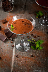 Cream coffee cocktail, chocolate martini with mint on black stone table, copy space