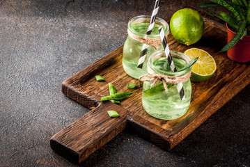 Healthy exotic detox drink, aloe vera or cactus juice with lime, on dark background copy space