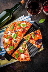 Pizza and red wine on dark background top view copy space