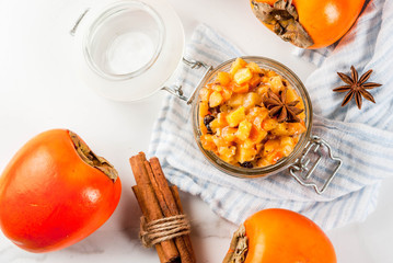 Traditional indian food recipes, Persimmon fruit Chutney with cinnamon and anise stars, white marble background copy space top view