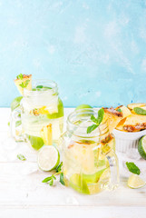 Tropical drink,  Pineapple mojito or lemonade with fresh lime and mint  light blue background, copy space