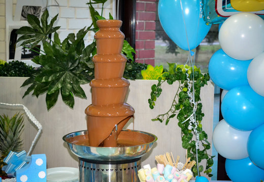 Chocolate fountain fondue. Sweets and making desserts. Festive decoration