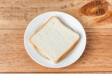 Fototapeta na wymiar white sliced bread on dish, wooden background